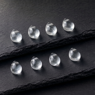 Eight rock crystal teardrops in rows on slate, crystal clear and shiny
