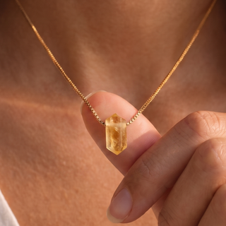 Zylinder Citrin Kette: goldgelbe Citrinsäule zwischen den Fingern am Dekolleté