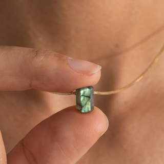 Zylinder Labradorit Kette: grünlich schimmernder Labradorit zwischen den Fingern