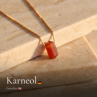 Karneol Zylinderanhänger auf Travertin mit Goldkette und Schriftzug Karneol