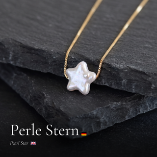 Sternperle an feiner Goldkette auf dunklem Schiefer mit Schriftzug Perle Stern