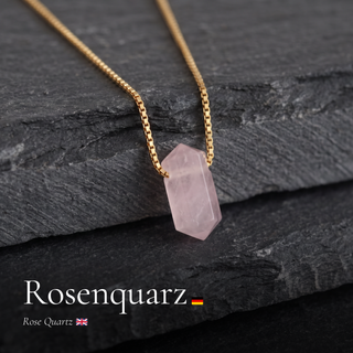 Rosenquarz Zylinderanhänger an Goldkette auf dunklem Schiefer mit Schriftzug Rosenquarz