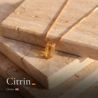 Citrin Zylinderanhänger an feiner Goldkette auf Travertinstufen mit Schriftzug Citrin