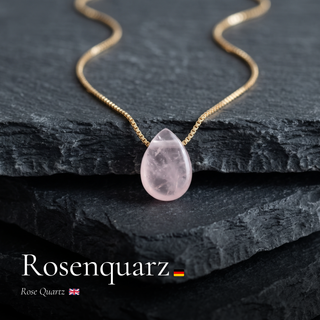 Rosenquarz Tropfen an Goldkette auf Schiefer mit Schriftzug Rosenquarz