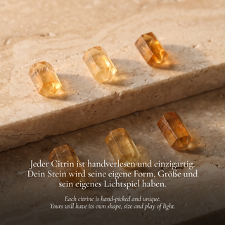 Five citrine cylinders on beige natural stone, warm yellow and orange tones