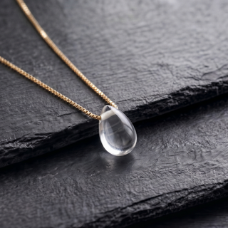Close-up of the transparent rock crystal teardrop on dark slate