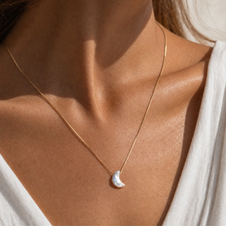 Perle Mond Kette nah am Schlüsselbein, schimmernder Halbmond im Licht