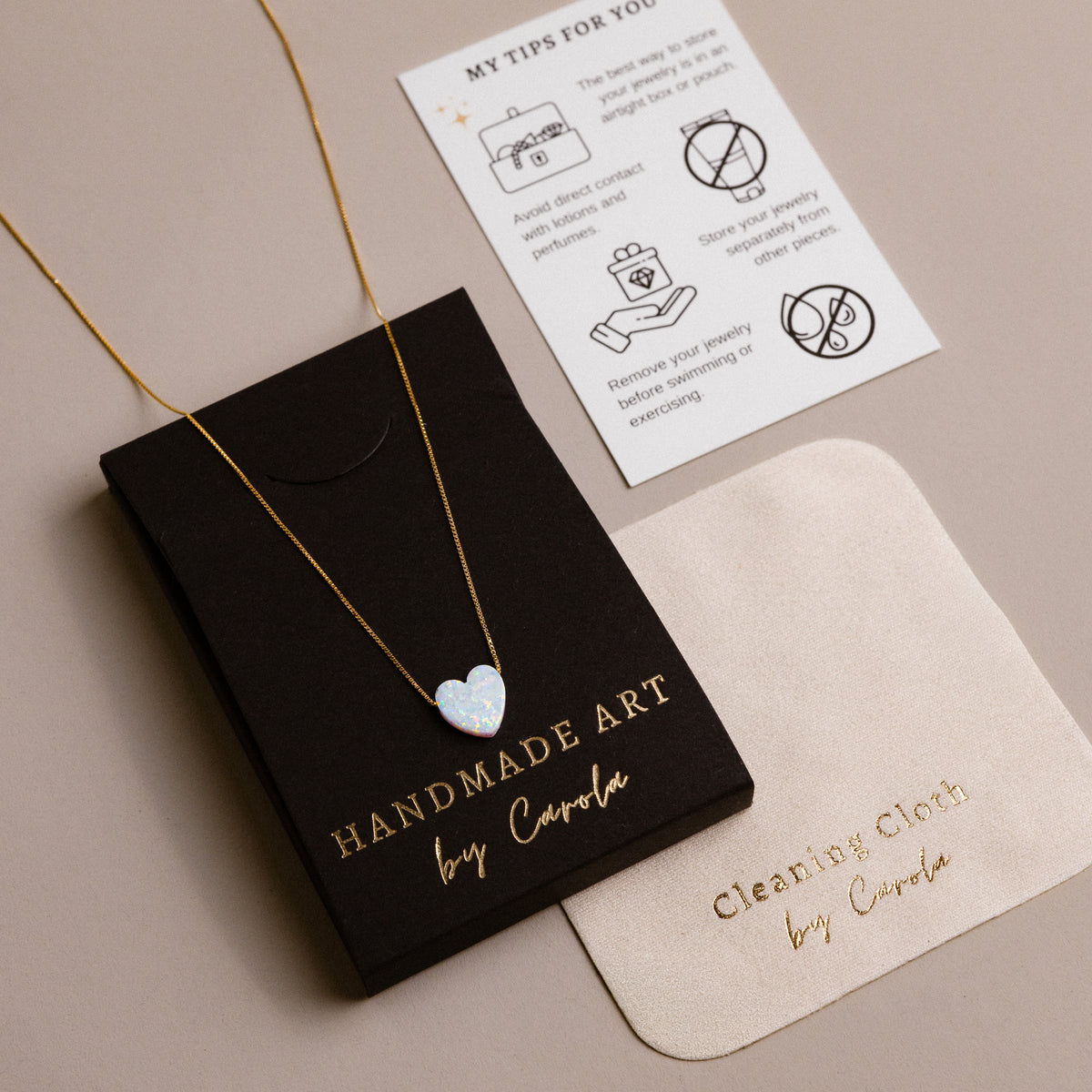 Black gift box from Handmade Art by Carola with a heart necklace, care card and polishing cloth