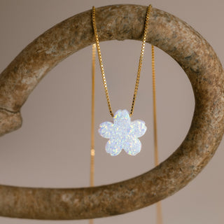 Gold flower necklace with a white cherry blossom on a curved stone-colored ring