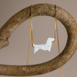 Goldene Dackelkette mit weißem Dackel an einem gebogenen steinfarbenen Ring