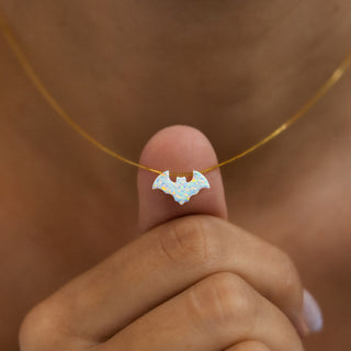 Fledermaus Kette in Opal-Optik: weiße Fledermaus auf dem Daumen, zeigt die Größe