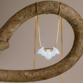 Goldene Fledermauskette mit weißer Fledermaus an einem gebogenen steinfarbenen Ring
