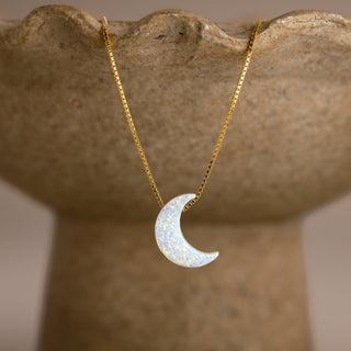 Halbmond Kette in Opal-Optik in Gold mit weißer Mondsichel an einer steinfarbenen Schale