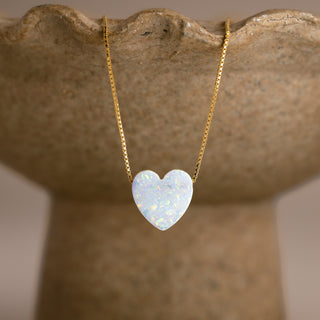 Herz Kette in Opal-Optik in Gold mit weißem Herzen an einer steinfarbenen Schale