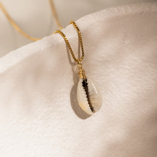 Muschelkette Gold über dem Rand einer hellen Keramikschale