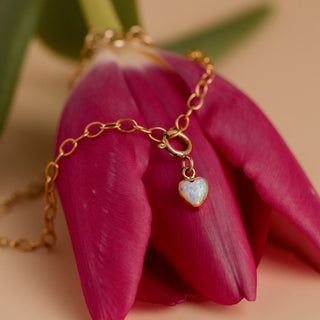 Opal pendant on a gold bracelet on a tulip