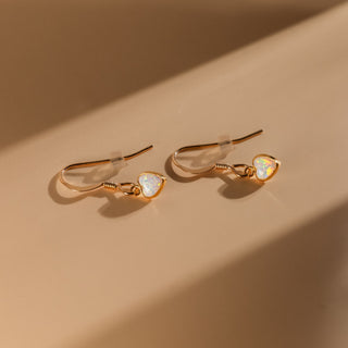 Opal earrings with clear earring backs in warm light