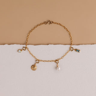 Armband mit mehreren Charms: die ovale Perle kombiniert mit Sonne, Herz und Aquamarin
