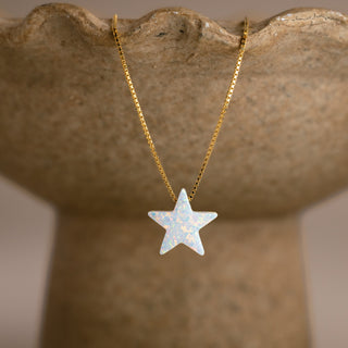Stern Kette in Opal-Optik in Gold mit weißem Stern an einer steinfarbenen Schale