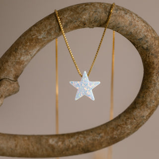 Goldene Sternkette mit weißem Stern an einem gebogenen steinfarbenen Ring