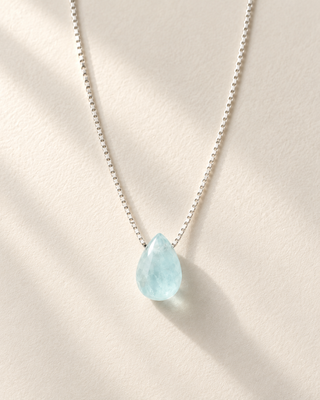Teardrop aquamarine necklace in 925 sterling silver on cream paper